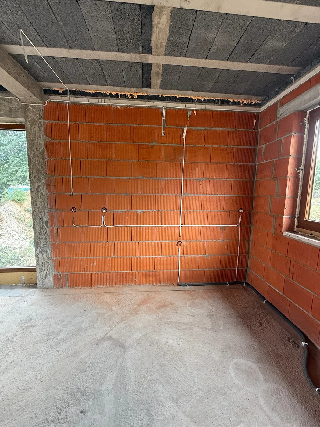 Instalacja elektryczna w stanie surowym na ścianie z pustaka ceramicznego.