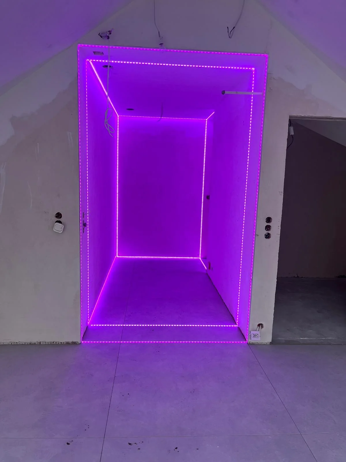 Portal wejściowy z dekoracyjnym oświetleniem LED w kolorze fioletowym.