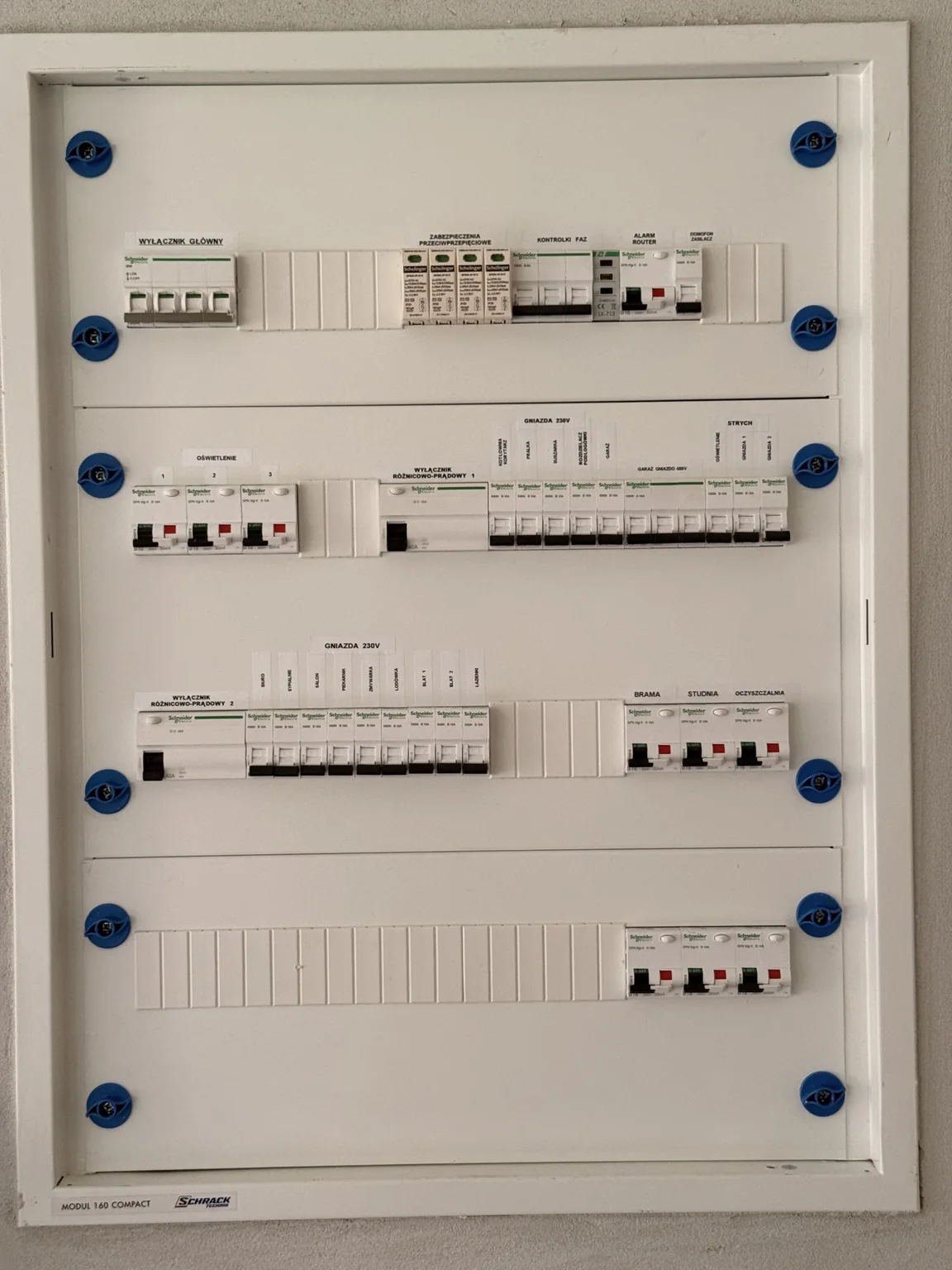 Zamknięta rozdzielnica elektryczna z opisanymi zabezpieczeniami.
